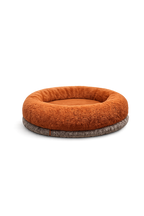 Donut-style Petyze cat bed with a thick rust-brown plush bolster and recessed center on a dark gray base, shown from a three-quarter angle against a transparent background.