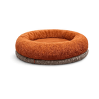 Donut-style rust-brown plush Petyze cat bed with recessed center on a dark gray base.